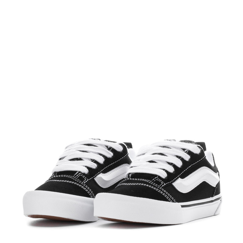 Kids black-and-white lace-up low-top skate shoes, front view with laces.