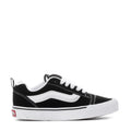 Black and white low-top sneakers with white stripe detailing and lace-up front