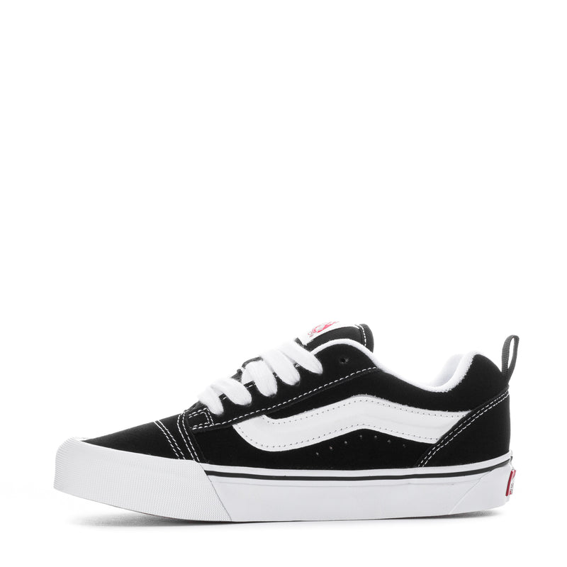 Black and white low-top lace-up sneaker with white stripe on the side and rubber sole