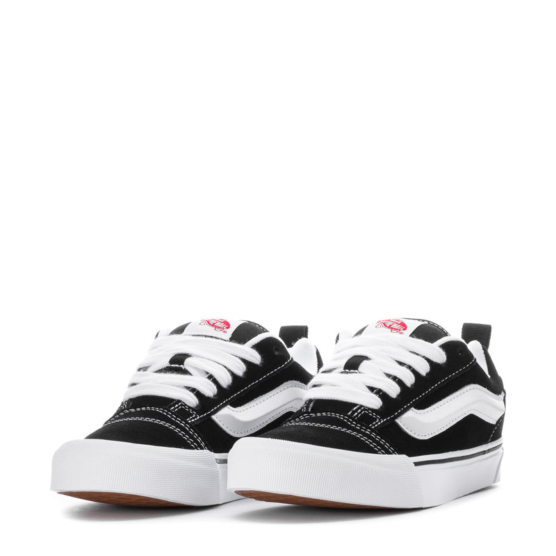Pair of black and white low-top lace-up sneakers with white stripe details