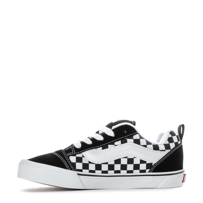 Youth black low-top sneakers with white checkerboard panels and white rubber sole