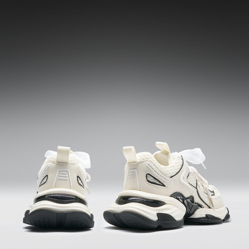 White sneakers with black soles on a gray background
