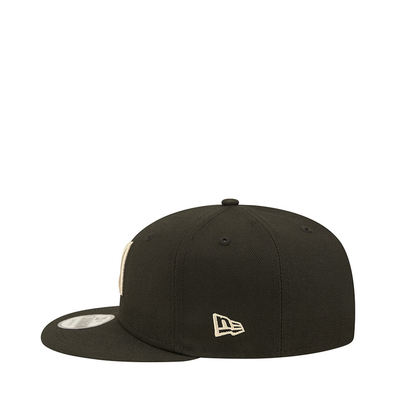 Dark baseball cap with small white LA monogram logo on front, side view