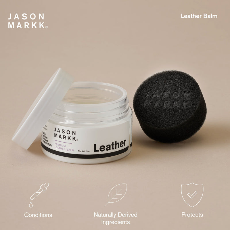 Leather conditioning balm jar with open lid and black sponge applicator on surface