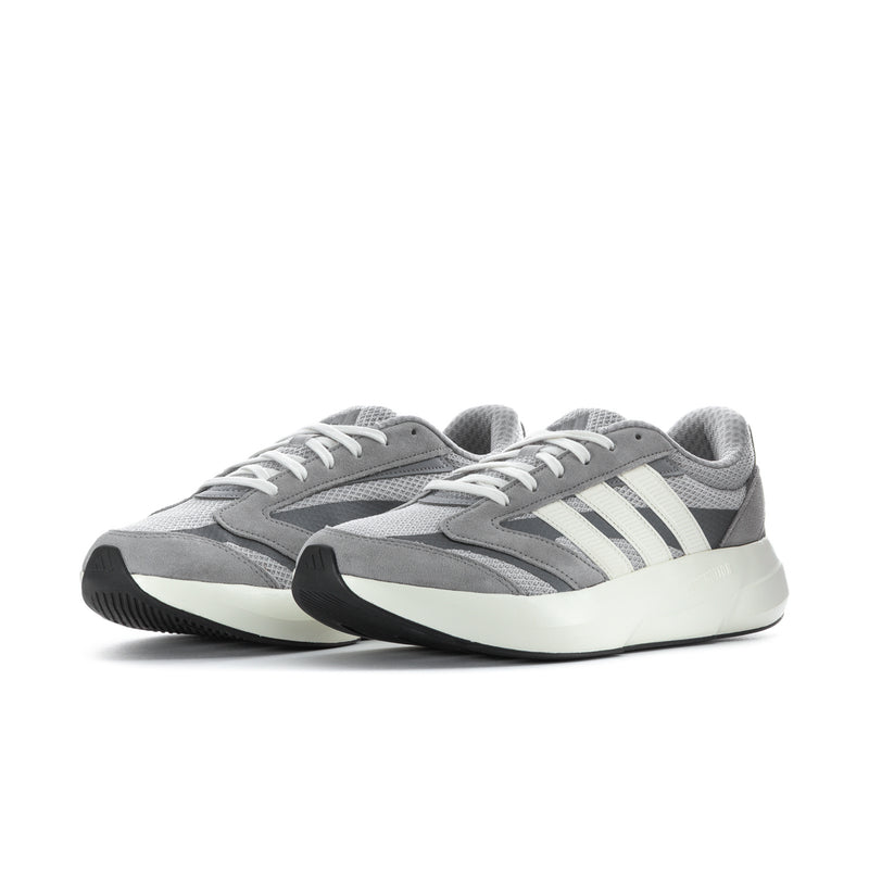Grey men's sneakers with three white stripes, lace-up front, angled side view
