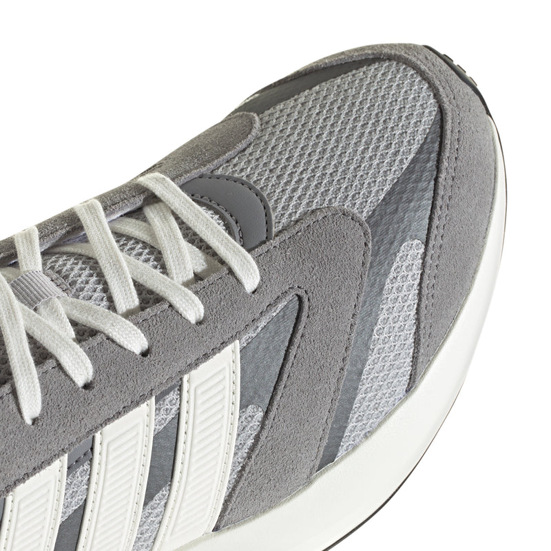 Grey sneaker upper close-up with mesh paneling, suede overlays, and white laces