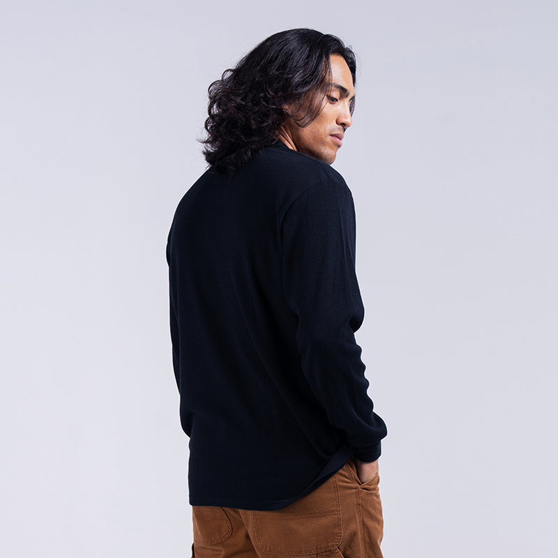 Black men's thermal long-sleeve crewneck shirt, side view with ribbed hem