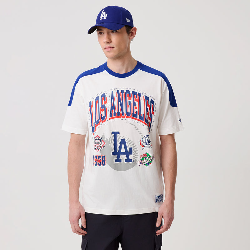 Men's white Dodgers varsity tee with blue raglan sleeves, front logo and cap-ready styling