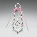 Decorative hair clip with silver beads, pink ribbon, and treble clef design on a gray background