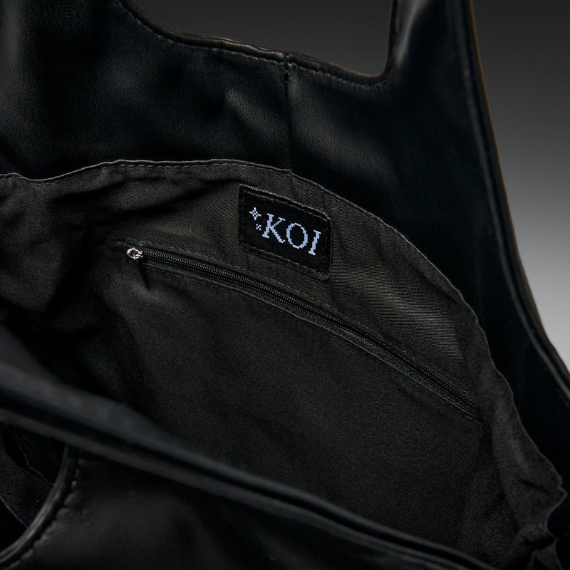 Black garment with a 'KOI' label on a dark background