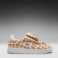 Checkered sneaker with decorative elements on a gray background