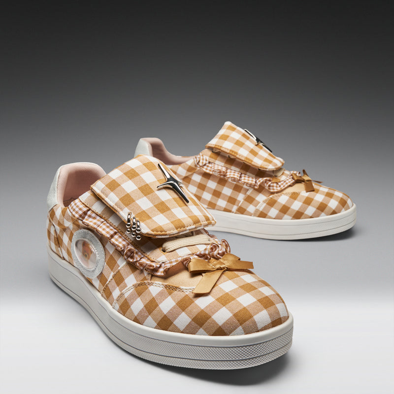 Pair of checkered sneakers with bows on a gradient background