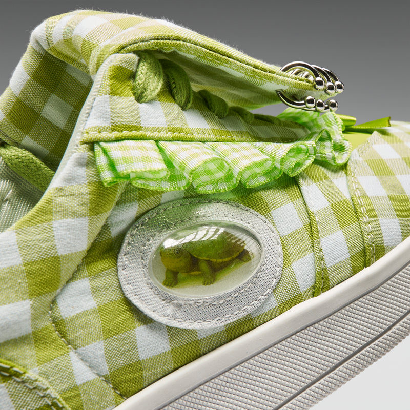 Green and white checkered shoe with frog emblem on a gray background