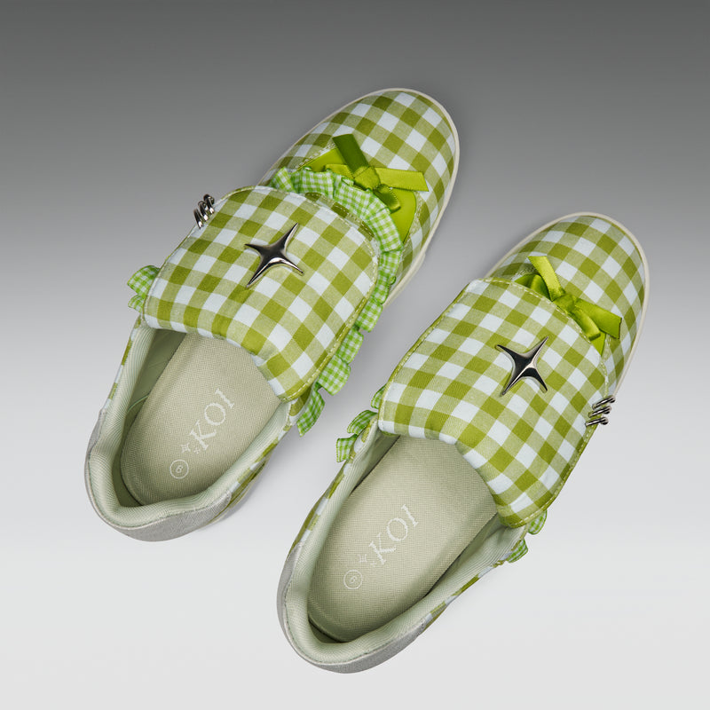 Green checkered slippers with bows on a gray background