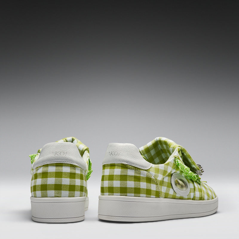 Green and white checkered sneakers with decorative elements on a gray background