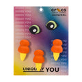 Dino Jibbitz charm pack with two black-and-green eye charms and three orange charms