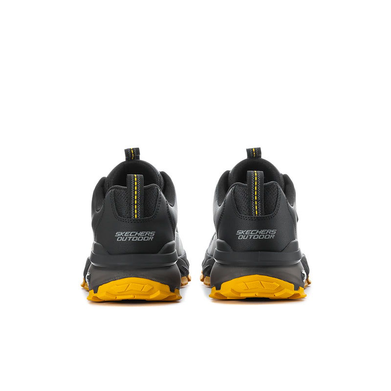 Black men's sneakers with yellow rubber outsole and Skechers branding on heel