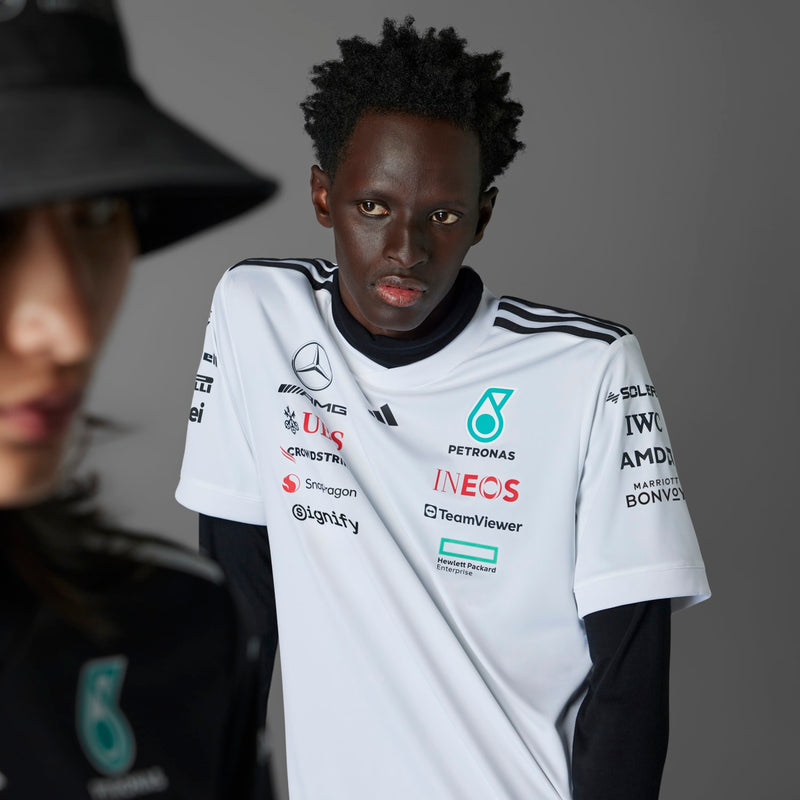 White replica football jersey with chest sponsor logos and black-trim collar, short sleeves.