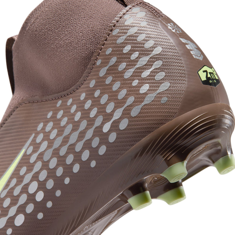 Youth soccer cleat toe close-up, plum with white dot overlay and green stud sole
