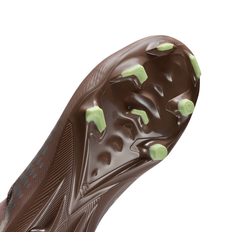Youth soccer cleat bottom view, plum outsole with green studs for firm ground