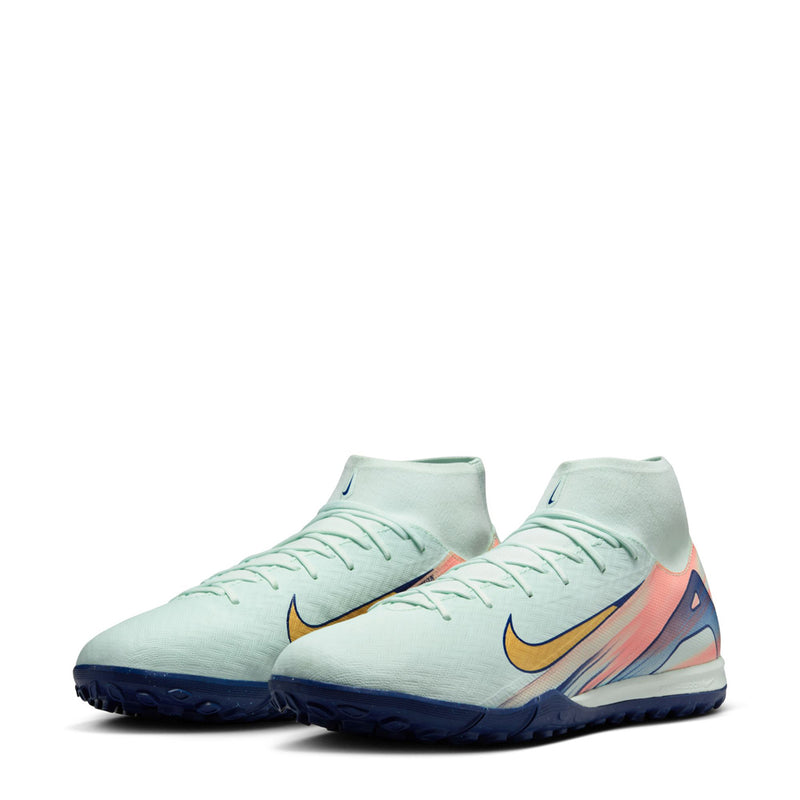 Pair of men's turf soccer cleats in light mint with gold swooshes and blue soles