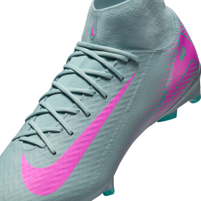 Close-up of light blue men’s soccer cleat with pink swoosh and teal outsole studs