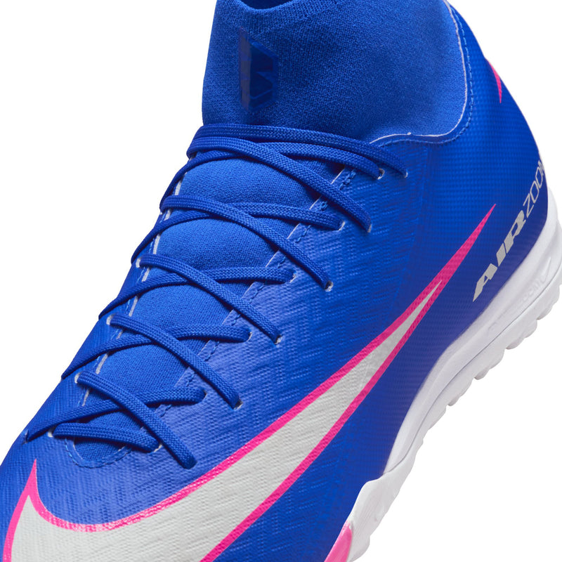 Close-up of blue lace-up soccer cleat with pink-and-white swoosh and white sole