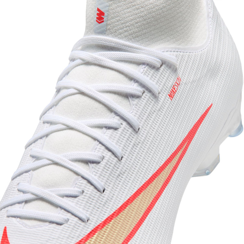 Close-up of men's white mesh soccer cleat with red swoosh and lace eyelets