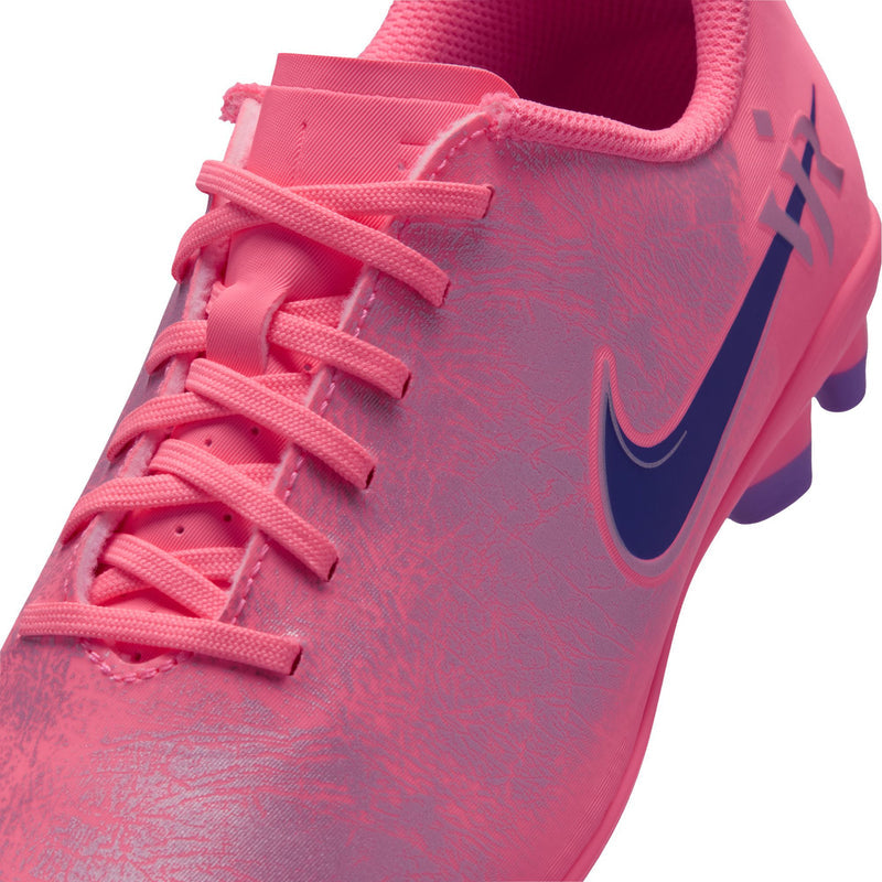 Youth soccer cleats close-up, pink textured upper with lace overlay and navy swoosh