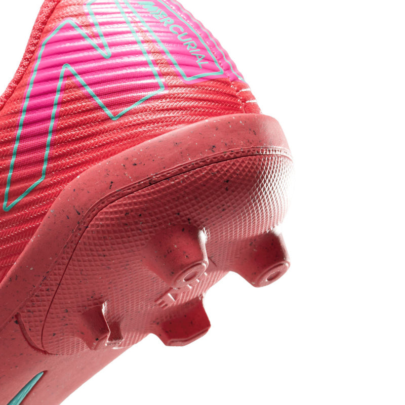 Kids red cleat side close-up with teal graphic, patterned upper and rubber studs