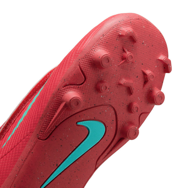 Kids red cleat outsole close-up with teal accent and round stud traction