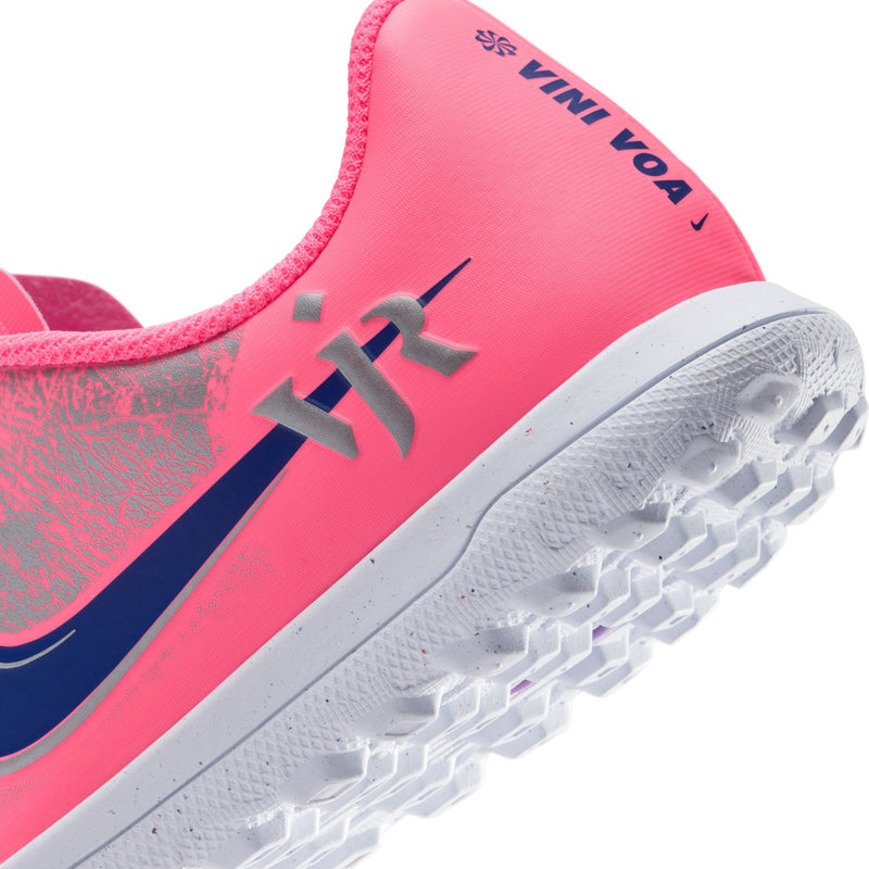 Close-up of youth cleat heel: pink collar with printed lettering and white turf outsole.