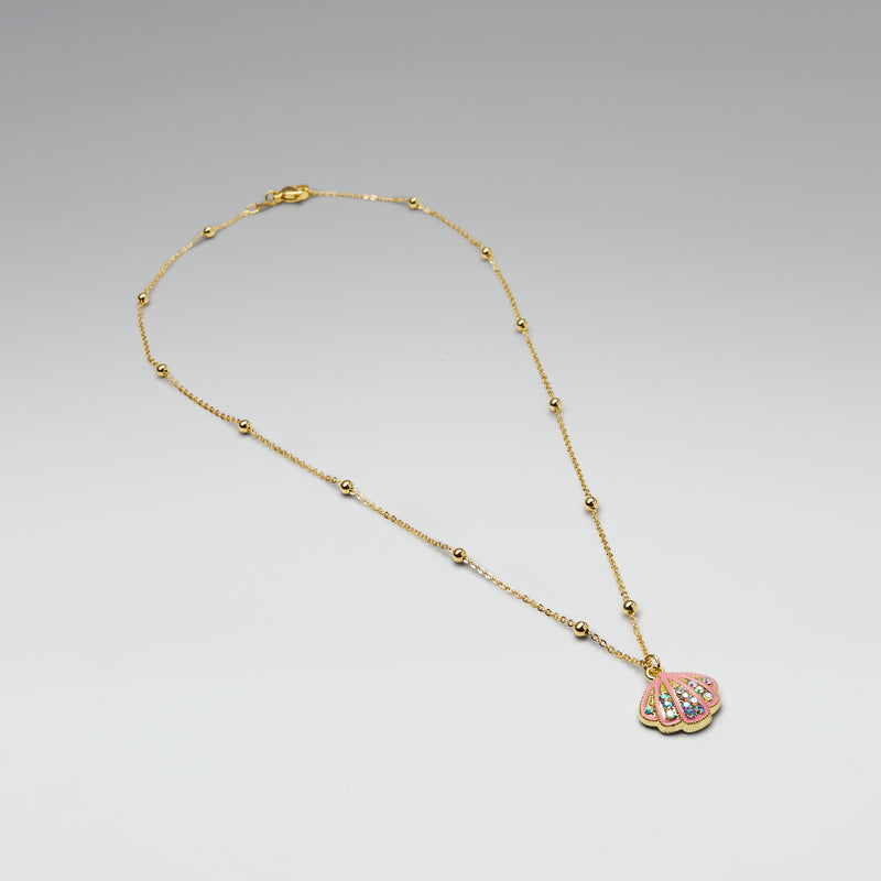 Gold necklace with a pink shell pendant on a light gray background