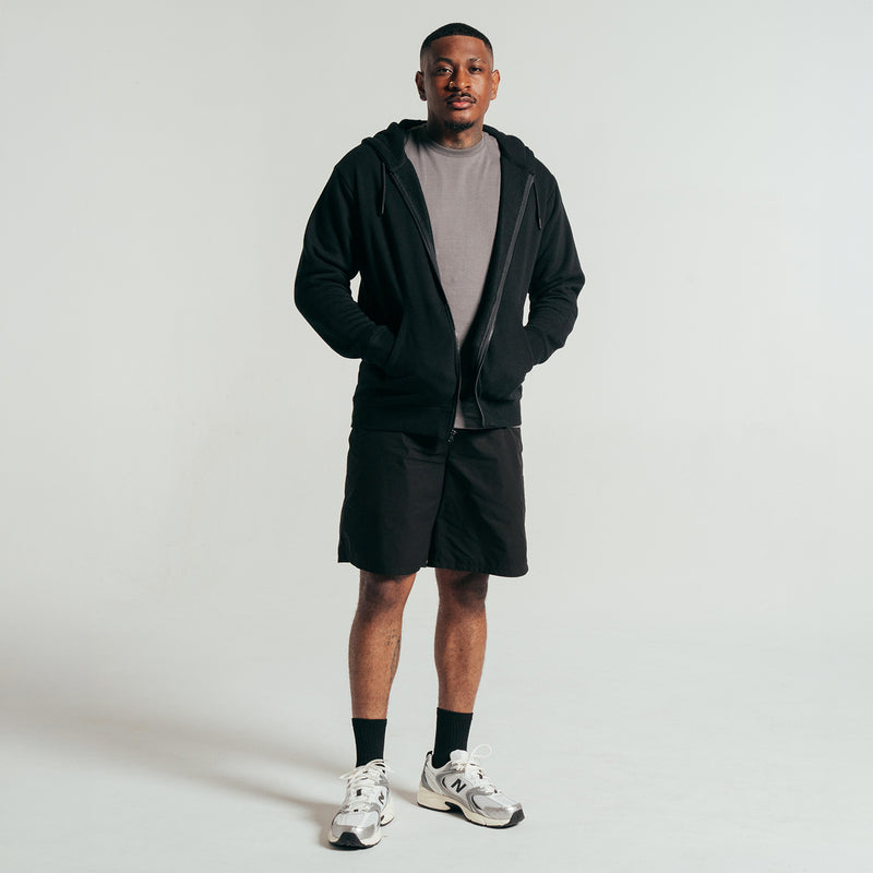 Black woven men's shorts with elastic waistband and straight above-knee hem.