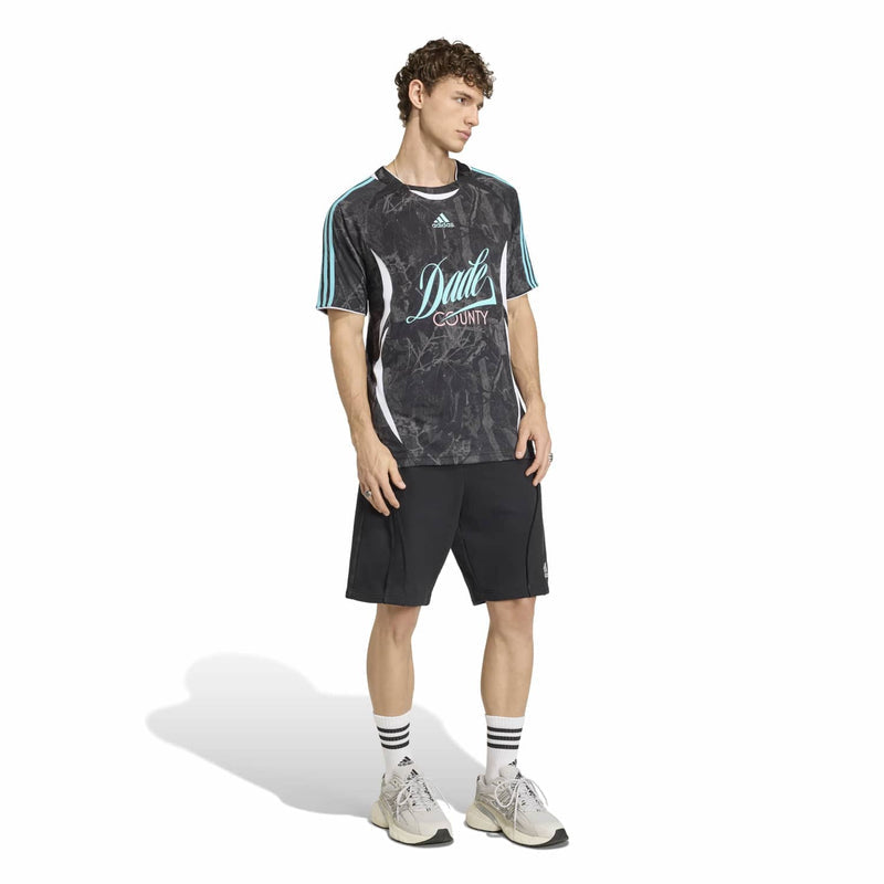 Men's dark graphic jersey with teal side stripes; worn with black shorts