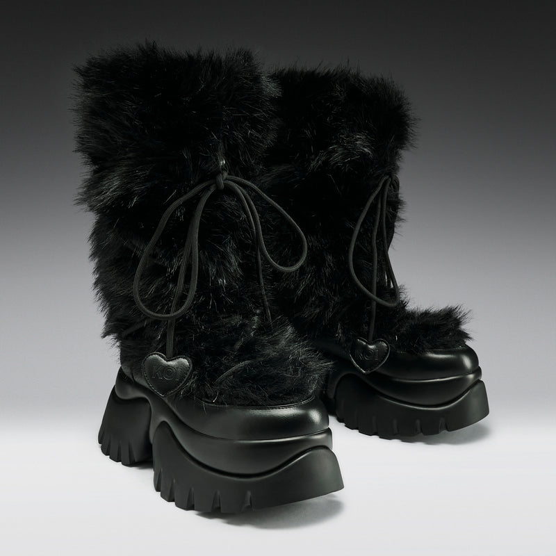 Black fur-lined boots with chunky soles on a gradient background