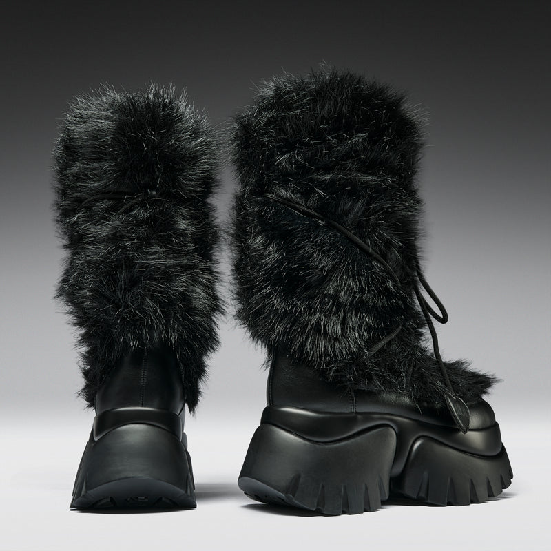Black boots with fur trim on a gradient background