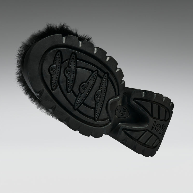 Black shoe sole with brand logo on a gradient gray background