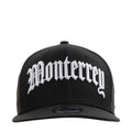 Black baseball cap with large white script front logo and curved brim