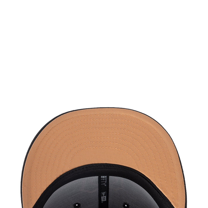 Snapback cap close-up: tan crown with black inner band and stitching details.