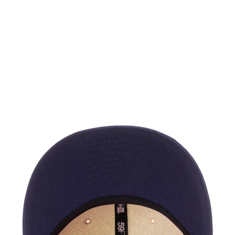 Navy baseball cap brim close-up with stitched edge and small interior label