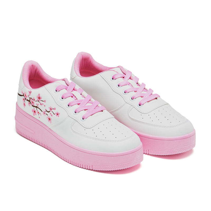 A pair of white platform trainers with pink floral embroidery on the top and a pink sole - 3/4 View