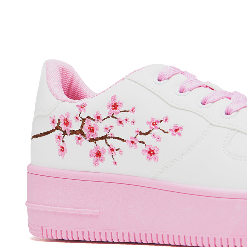 A pair of white platform trainers with pink floral embroidery on the top and a pink sole - Heel Detail