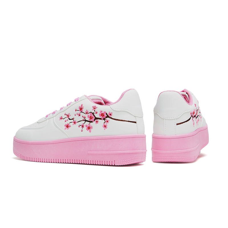 A pair of white platform trainers with pink floral embroidery on the top and a pink sole - both black view