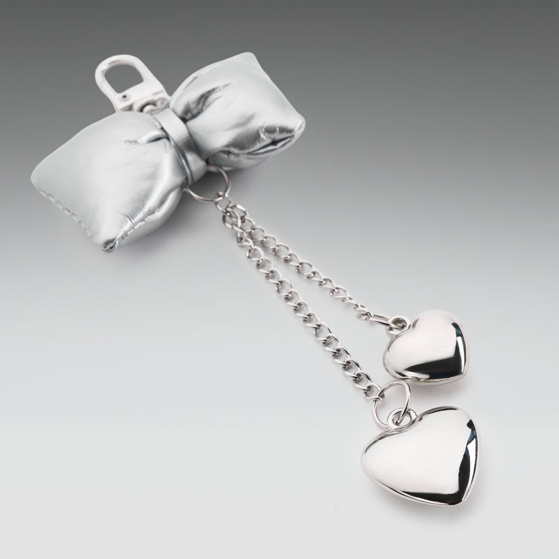 Silver bow with heart-shaped pendants on a gray background