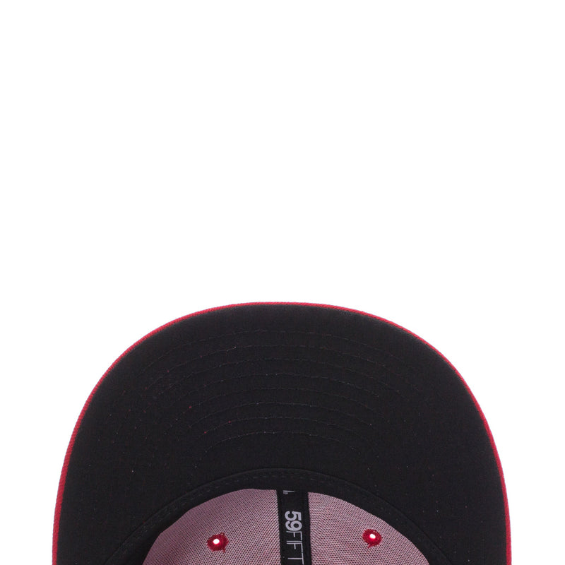 Black baseball cap underside close-up with stitching and red eyelets