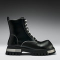 Black leather boot with white laces on a gray background