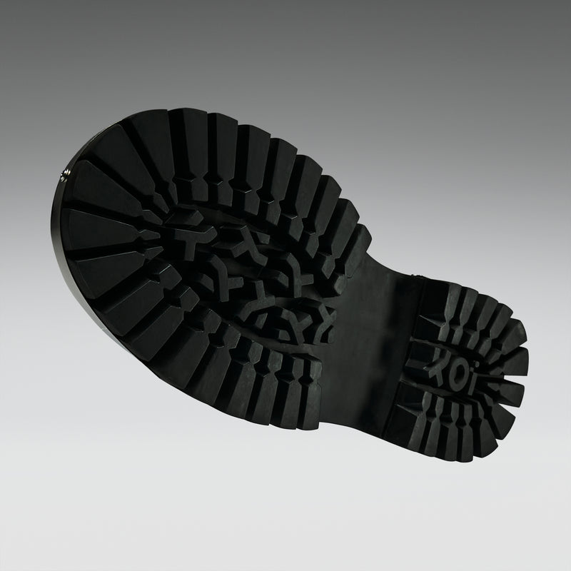 Close-up of a black rubber boot sole on a gray background