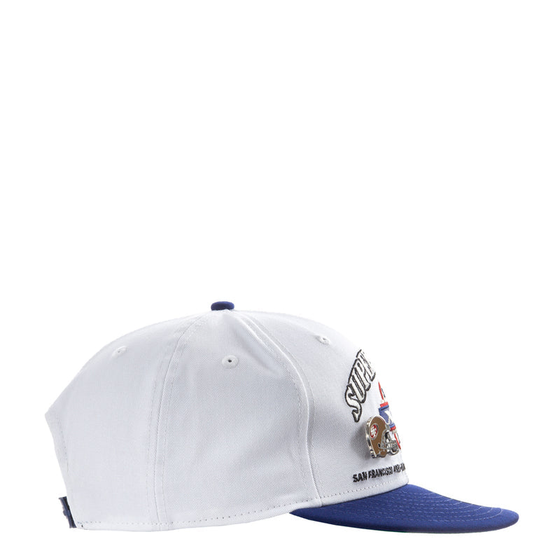 White two-tone baseball cap side view with embroidered Super Bowl patch and blue brim
