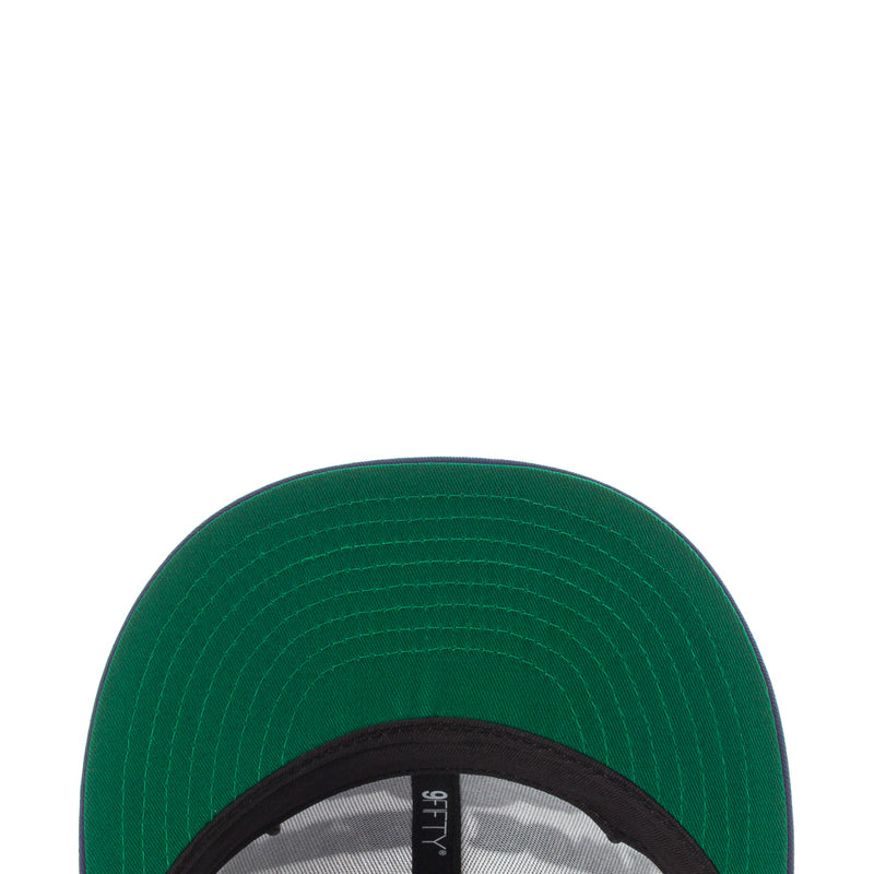 Green baseball cap brim close-up with stitched paneling and black inner edge